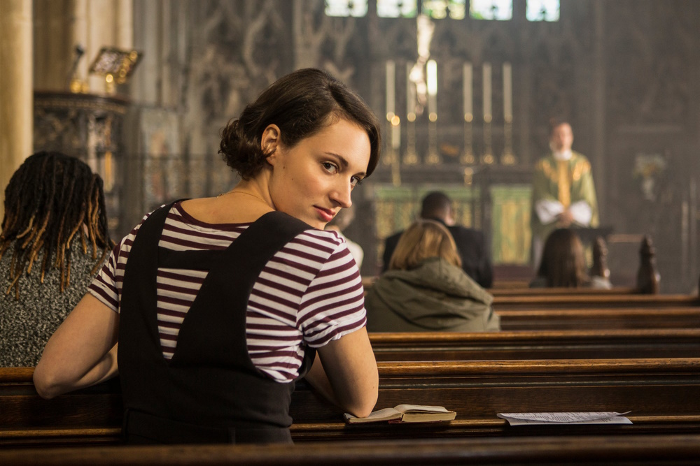 Image of Fleabag sitting in church, looking back at the camera.